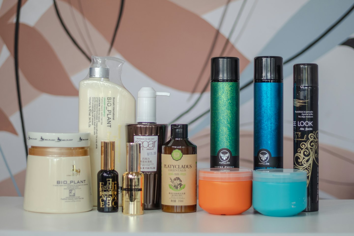 Various hair care bottles and styling products arranged on a surface.